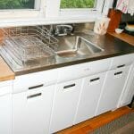 2011 elkay stainless steel drainboard sink installed onto a vintage steel kitchen cabinet
