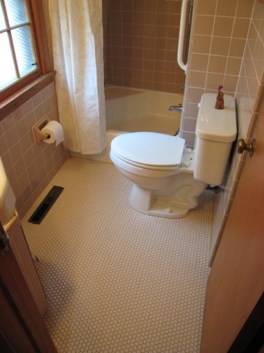 beige tile bathroom with penny round floor tile
