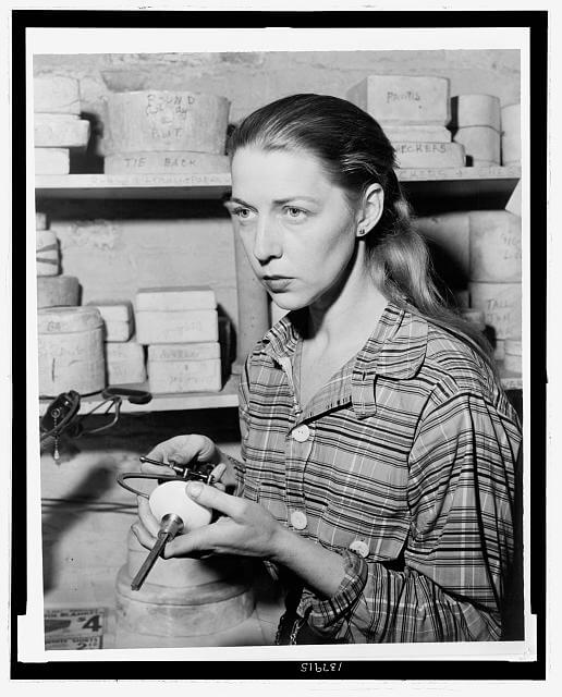 Photo of artist Carol Janeway in 1949 holding doorknob she designed and 