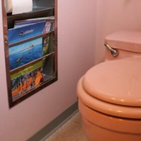 pink bathroom with recessed metal magazine rack