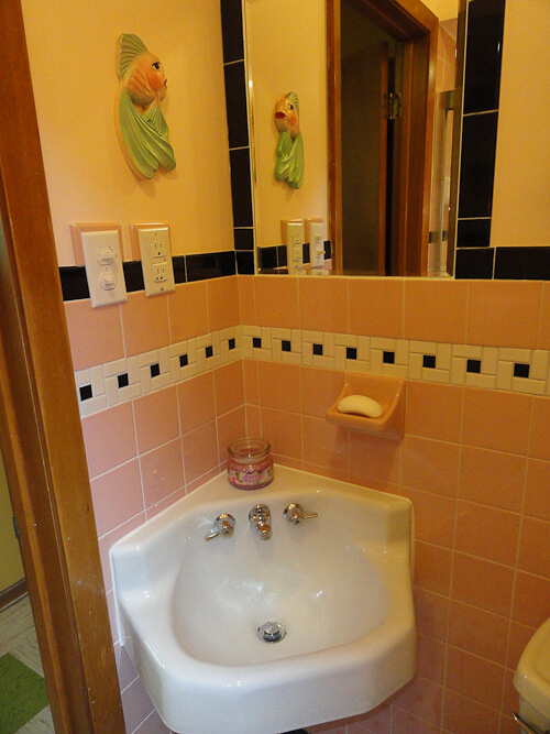 pink and black bathroom with original corner sink