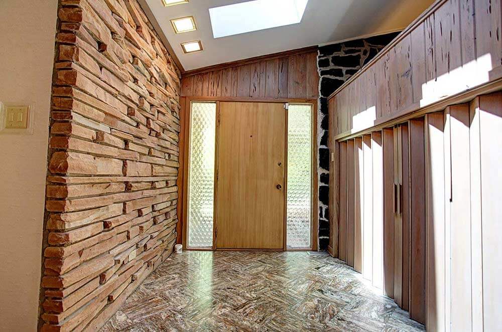 dramatic foyer with pecky cypress and rock wall 