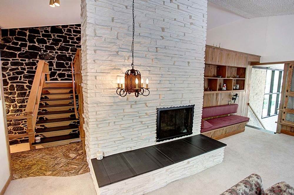 rock wall brick fireplace and pecky cypress in a mid century living room