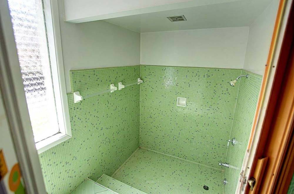 walk in shower with green mosaic tile