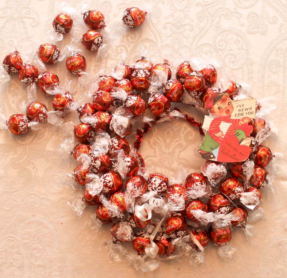 adding a valentine to wreath made of lindt chocolates