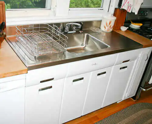 2011 elkay stainless steel drainboard sink installed onto a vintage steel kitchen cabinet