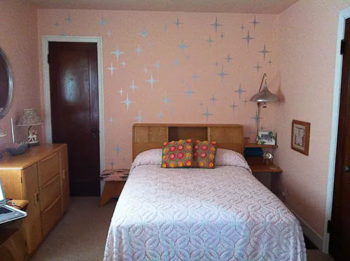 starburst stencils on a bedroom wall done in metallic paint