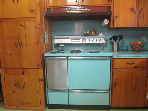 vintage turquoise stove in a knotty pine kitchen