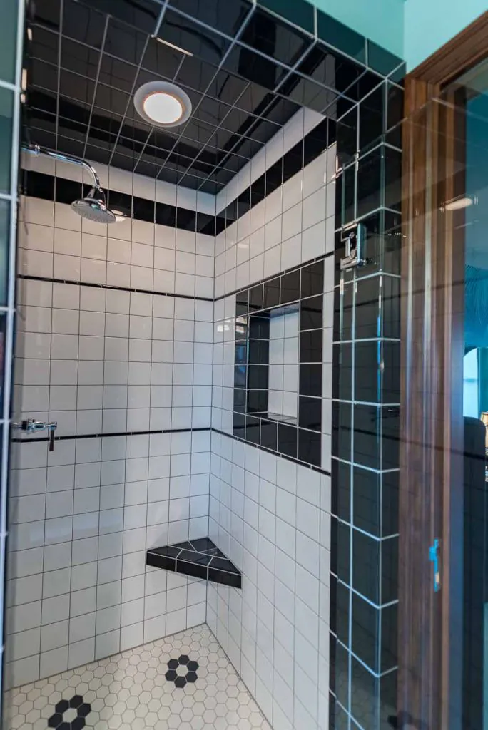 white tile shower with black trim
