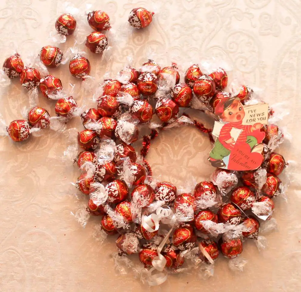 adding a valentine to wreath made of lindt chocolates