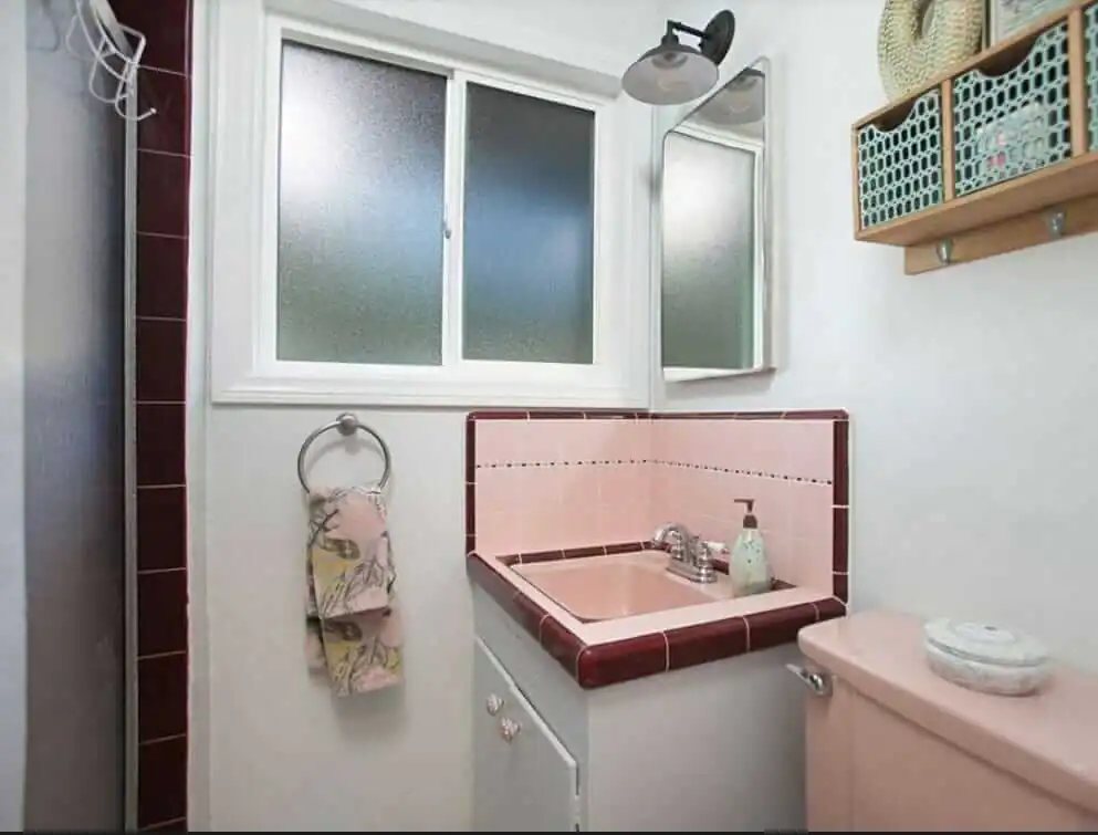 pink bathroom tile around a corner sink
